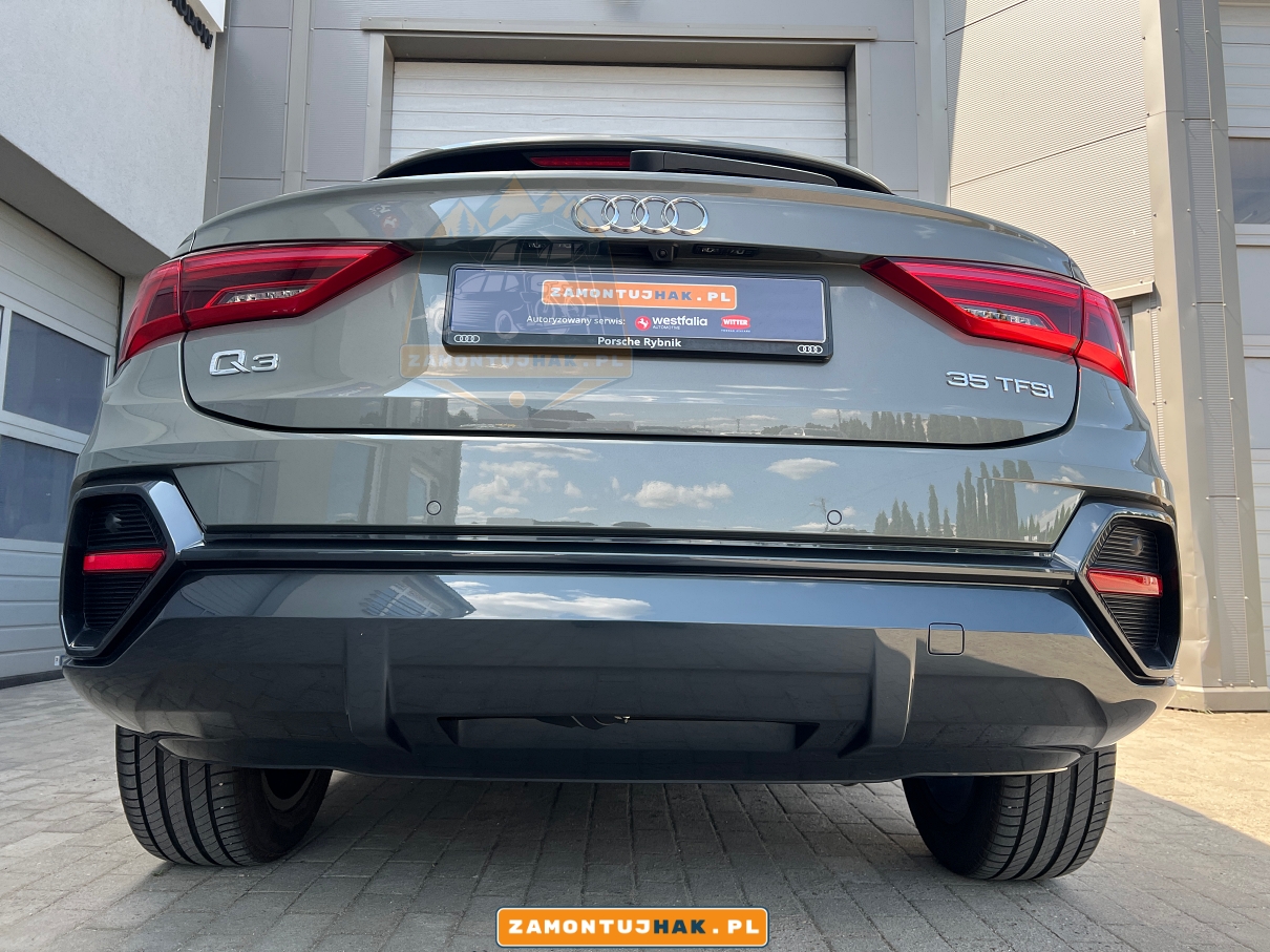 NA ZDJECIU SAMOCHOD AUDI Q3 F3N SPORTBACK OD TYLU POKAZANE NIEWIDOCZNOSC ELEKTRYCZNEGO HAKA MODEL R12 PO MONTAZU W SAMOCHODZIE PRZEZ PROFESJONALNY WARSZTAT MONTUJACY HAKI HOLOWNICZE W WIELKOPOLSCE WESTFALIA POZNAN